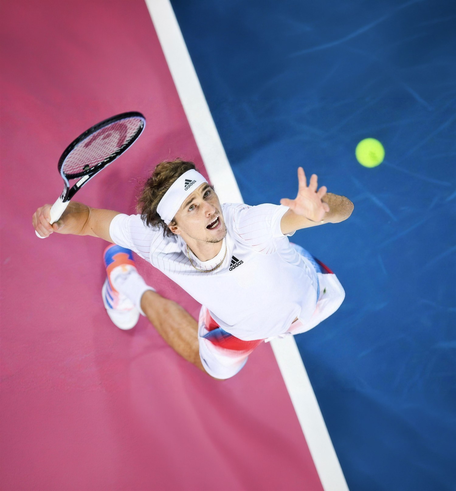Alexander Zverev streckt sich beim Aufschlag, von oben fotografiert, der Ball in der Luft